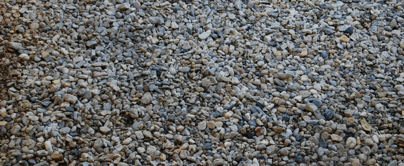 Frisch angelegte Einfahrt mit hellgrauem Kies und gepflegtem Randstein